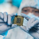 Gloved hands of contemporary scientist holding microchip